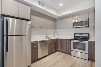 A modern kitchen with stainless steel appliances and wooden cabinets.